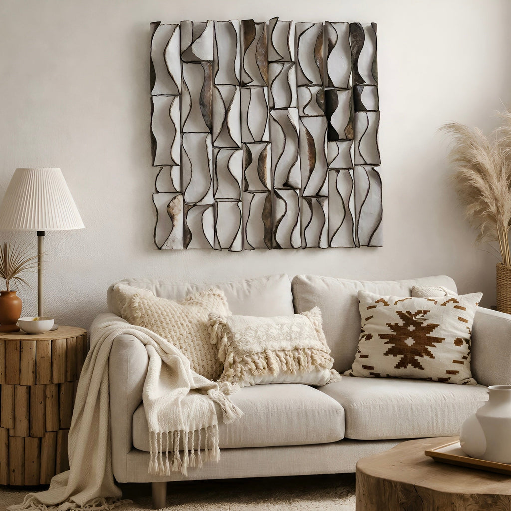 3D ceramic wall art sculpture with hand-formed hourglass column segments in warm cream and bronze glaze, mounted on a living room feature wall